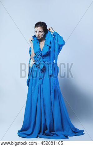 Woman With A Pieces Of Glass Or Ice On Her Face, Wearing Beautiful Blue Dress