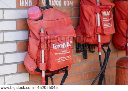 Russia, Rostovskaya Oblast, 2021 September 01: Knapsack Fire Extinguishers On A Wall. Sign On Russia