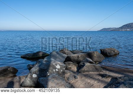 Boulders As A Part Of A Wave Breaker In A Lake. Picture From Lake Vattern, Sweden. Blue Water And Sk