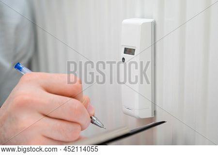 Close Up Man Shows On The Thermoregulator On The Battery. Increasing Costs On Heating, Gas And Water
