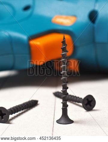 Screwdriver And Screws Lie On A Sheet Of Drywall. The Gypsum Sheet Is Marked With A Pencil. Building