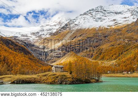 Little Stone House On The Islet Of The Palu Lake Below Piz Palu Glacier In Swiss Alps In Autumn Day,