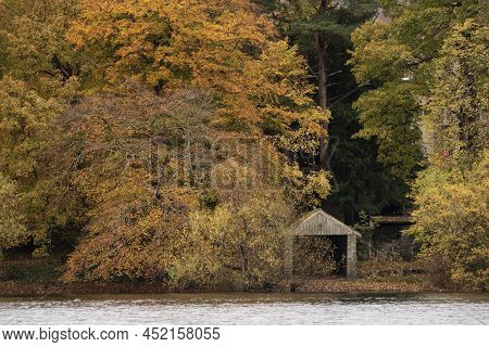 Epic Landscape Image Of Boathouse On Derwentwater In Lake District Surrounded By Vibrant Autumn Colo