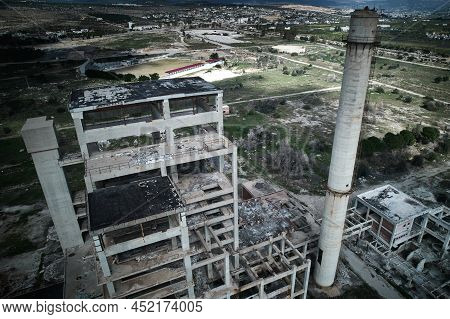 Concrete Structures Of Abandoned Plant. Chimney And Skeletons Of Abandoned Multi-storey Buildings. A