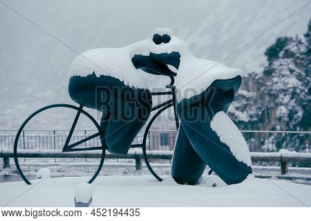 Escaldes Engordany, Andorra: 2022 April 2: Sculpture By Botero Cyclist And Woman Kiss. Whit Snowfall