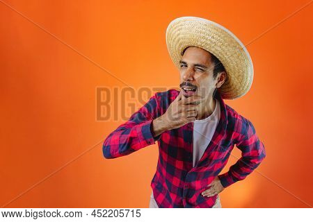 Black Man With Junina Party Outfit  Isolated On Orange Background.