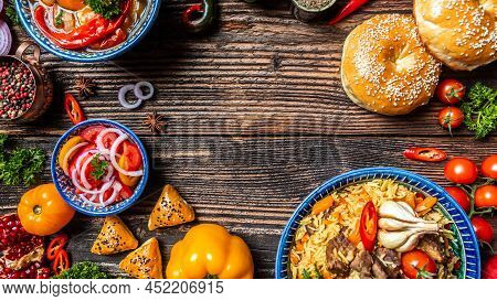 Traditional Uzbek Meal Called Pilaf. Rice With Meat On Plate With Oriental Ornament On A Dark Wooden