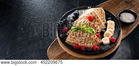 A Plate Of Pancakes With Cheese And Fruits