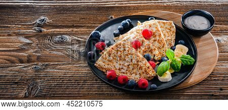 A Plate Of Pancakes With Cheese And Fruits