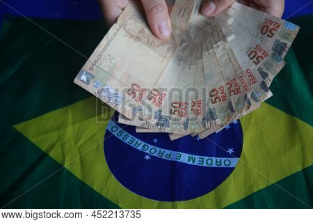 Brazilian Money Next To A Flag