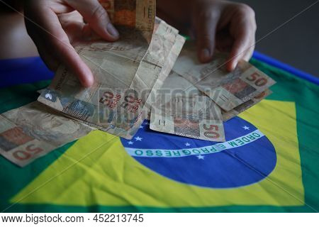 Brazilian Money Next To A Flag