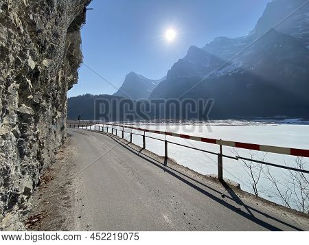Paved Road By The Alpine Resevoir Lake Klöntalersee (kloentalersee Or Klontaler Lake) And In The Klö