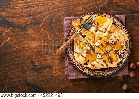 Crepes Suzette With Oranges And Chocolate. Thin Crepes With Chocolate Spread, Hazelnuts And Orange S