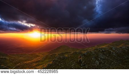 Purple Sunset With Green Mountains And Clouds