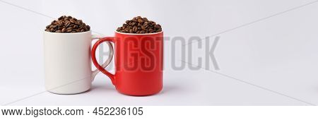Red And White Coffee Mugs Turned To Each Other By Handles Full Of Coffee Beans
