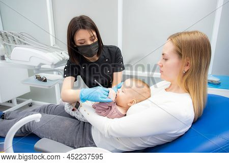 Mom And Baby At The Reception At The Pediatric Dentist. First Visit To The Dentist. Diagnosis And Tr