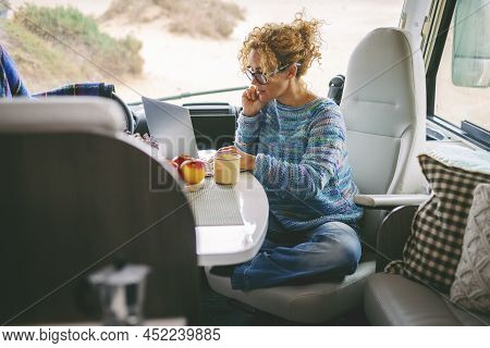 Adult Nice Woman Work On Laptop Sitting In A Camper Van Dinette Enjoying Freedom Travel Vacation Or 