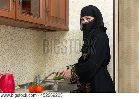 Muslim Woman In The Kitchen Preparing Fresh Vegetable Salad.