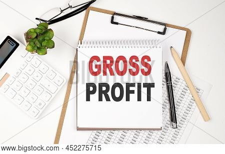 Office Desk Table With Paper Sheet, Notepad ,chart And Calculator. Top View Text Gross Profit