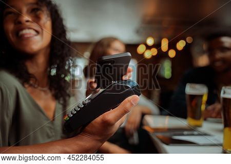 African American Female Tapping Card Machine With Cellular Device