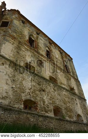 High Wall Of An Old Stone Fortress With Loopholes And Embrasures