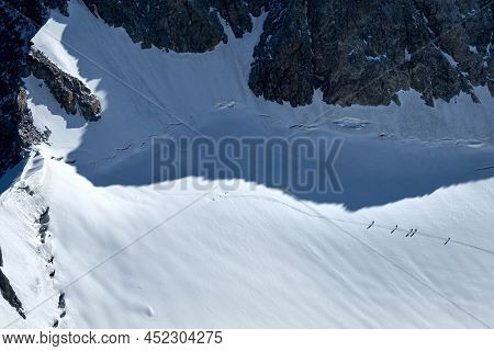 Bunch Of Mountaineers Climbs Or Alpinists To The Top Of A Snow-capped Mountain On Glacier