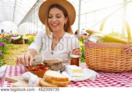 Smiling Beautiful Girl Having Picnic. Young Woman Takes A Strawberry. Fresh Harvest And Zero Kilomet