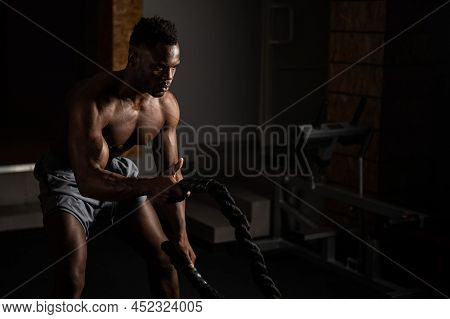 Attractive African American Man With Naked Torso Doing Endurance Exercises With Trope.