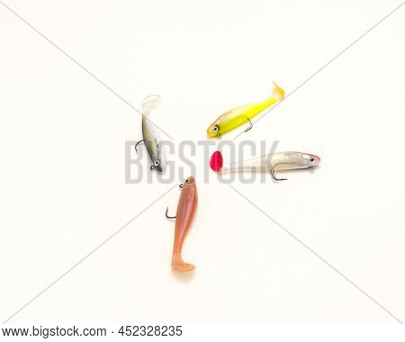 Four Jig Head Shad Soft Fishing Lures With Hook And Paddle Tail Swimbaits Isolated On White Backgrou