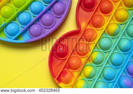 Popular Silicone Multi-colored Anti-stress Toy Pop It On Yellow Background Flat Lay Top View Close-u