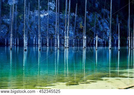 Landscape Of A Mountain Lake With Trunks Of Flooded Fir Trees. Kaindy Lake In Kazakhstan. Kolsay Lak