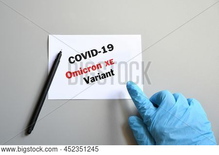 Covid-19 New Omicron Xe. Hand Of The Doctor In Blue Glove With Marker And Writing 