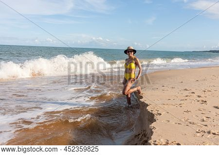 Fit Women In A Yellow Bikini At The Beach Known As Pitinga, In Arraial D\' Ajuda, Bahia, Brazil