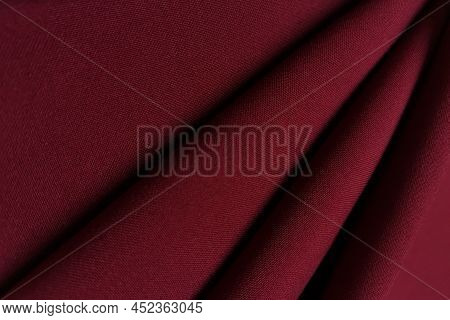 Red Crumpled Or Wavy Fabric Texture Background. Abstract Linen Cloth Soft Waves. Gabardine Wool Fabr