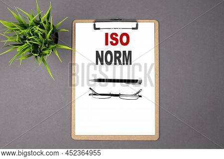 Iso Norm On Brown Clipboard On The Grey Background. Business Concept