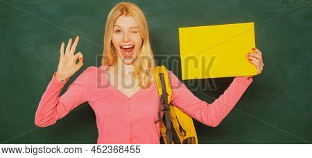 Student Girl Holding Empty Faper For Product. Excited Amazed Student. Portrait Of Teacher At School.
