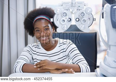 Happy Young Woman African American Eye Exam With Diagnostic Ophthalmology In Optical Clinic. Profess