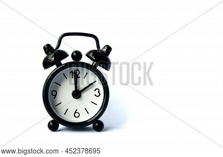 Black Alarm Clock Isolated On White Background. The Clock Set At 2 O'clock. Copy Space.