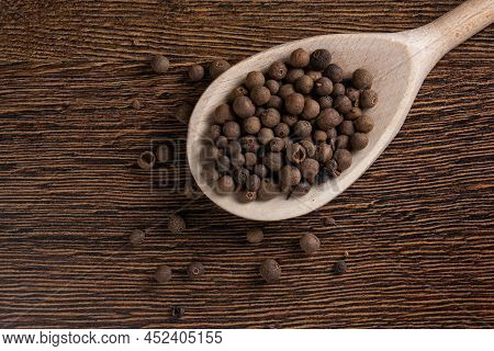 Allspice, Pimento Spice, Jamaican Pepper In Wooden Spoon Wooden Background.