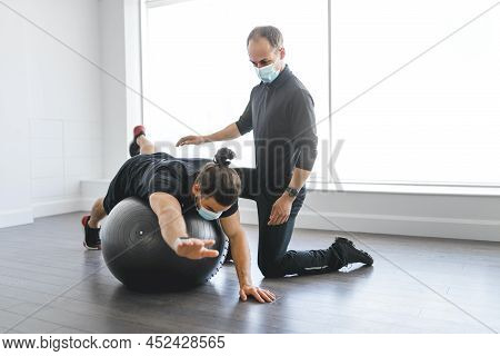 Physiotherapist Doing Therapeutic Exercises For Patient At The Clinic.