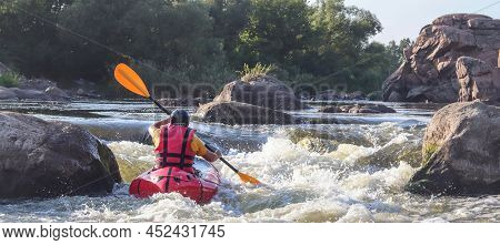 A Man Rowing Inflatable Packraft On Whitewater Of Mountain River. Concept: Summer Extreme Water Spor