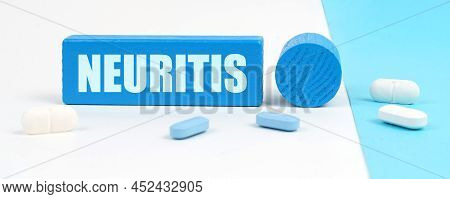 Medical Concept. On A White And Blue Surface Are Pills, A Stethoscope, A Pen And A Wooden Sign With 
