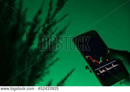 Stock Market Graph For Tranding And Investment In Security Exchange. Woman Holding Phone Show The St