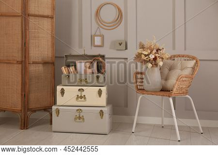 Wicker Chair With Dry Flowers And Storage Trunks Indoors. Interior Design