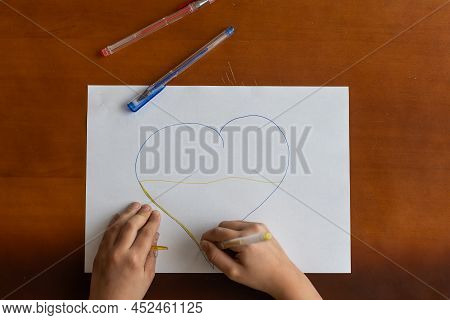 Childrens Hand With Pencil Draws The Heartl