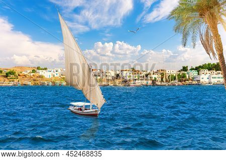 Sailboats In The Nile In Front Of Traditional Buildings, Asuan, Egypt