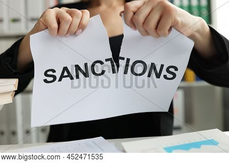 Person Tore Up Document With Words Of Sanction. Blocking Economic Business And Food Sanctions Concep