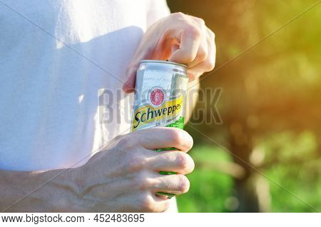 Man's Hands Open A Tin Can Of Schweppes In The Sunlight. Jar Of Schweppes In Men's Hands - Izmail, U