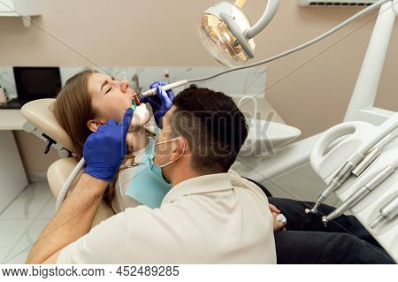 A Highly Qualified Dentist Treats The Teeth Of A Young Patient. Pain Free Dental Treatment. Modern D