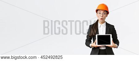 Impressed Asian Female Construction Engineer, Businesswoman In Safety Helmet And Suit Showing Chart,